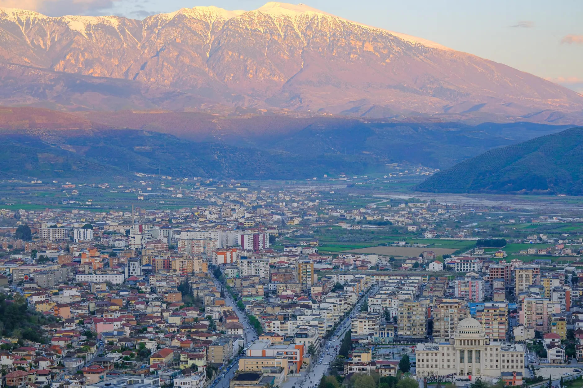 Stunning aerial view of Shkoder, Albania, with snow-capped mountains in the background and vibrant cityscape.