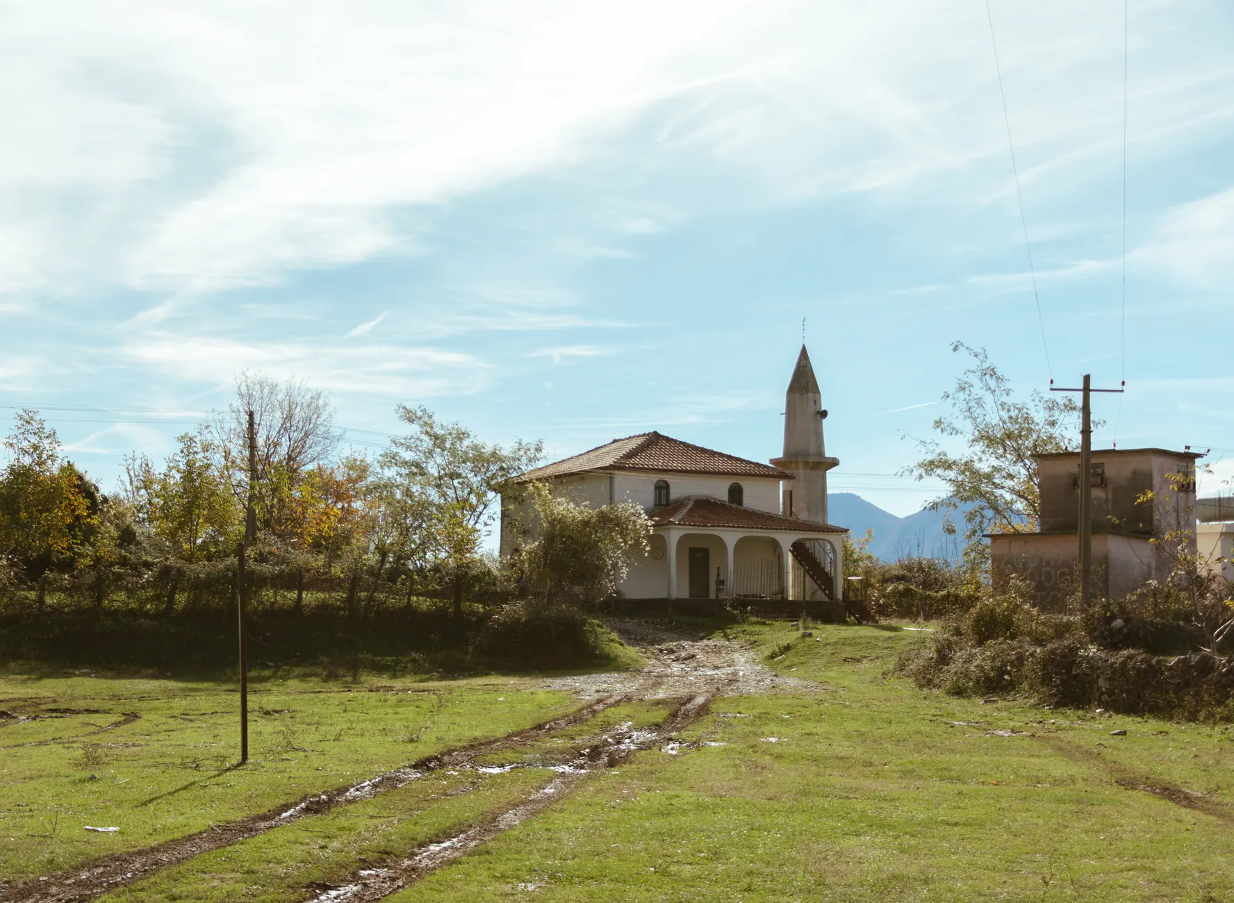 Serene rural landscape featuring a mosque and a winding road in Tirana, Albania.